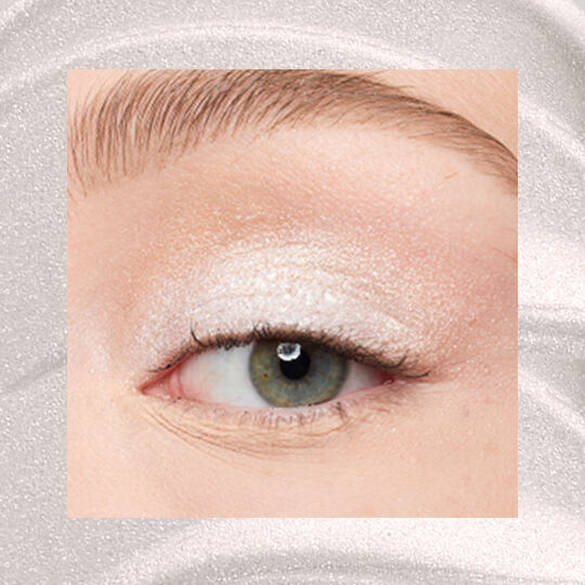 Close-up of an eye area with NYX Professional Makeup Lid Lingerie Cream Eye Pigment in Satin Silver, shown on a shimmering silver textured background.