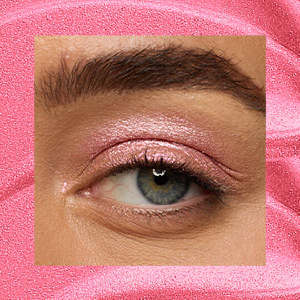 Close-up of an eye area with NYX Professional Makeup Lid Lingerie Cream Eye Pigment in Push-Up Pink, shown on a duochrome pink textured background.