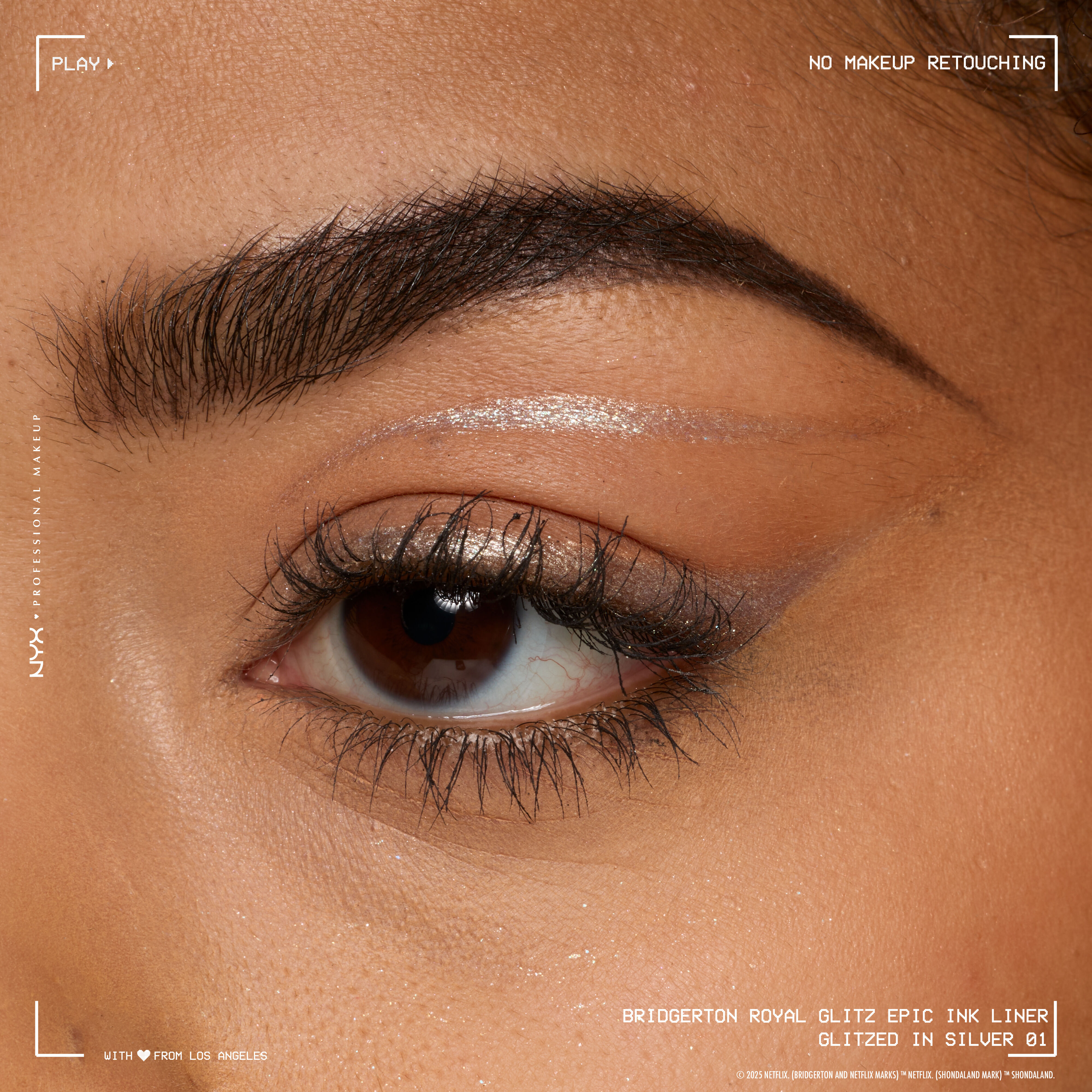 A close-up macro shot of a person's eye, with a silver eyeliner expertly applied along the waterline and inner corner, showcasing the product's finish on skin in shade 01 Glitzed In Silver