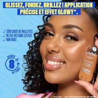 Smiling model holding a NYX Buttermelt Stix highlighter in a golden shade. Text reads: "Butta highlight from head to toe! Butta smooth glide, butta quick glow." Additional callouts: "No glitter fall-out, non-cakey, non-greasy feel." 8-hour wear badge and icons for vegan, cruelty-free, no retouching are included.